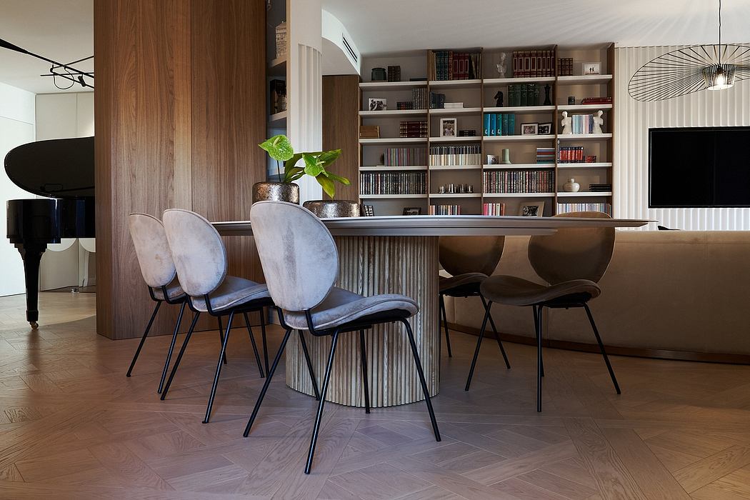 Contemporary dining room with sleek chairs and bookshelf.