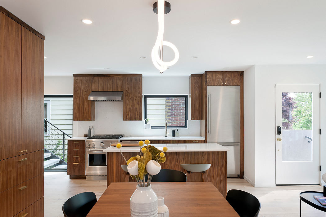 Modern kitchen with wooden cabinets and a unique white pendant light.