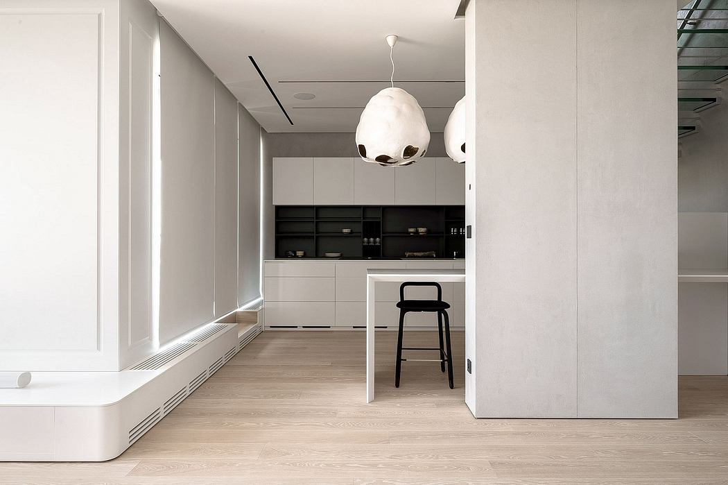 Modern minimalist kitchen with white cabinets and unique pendant lights.