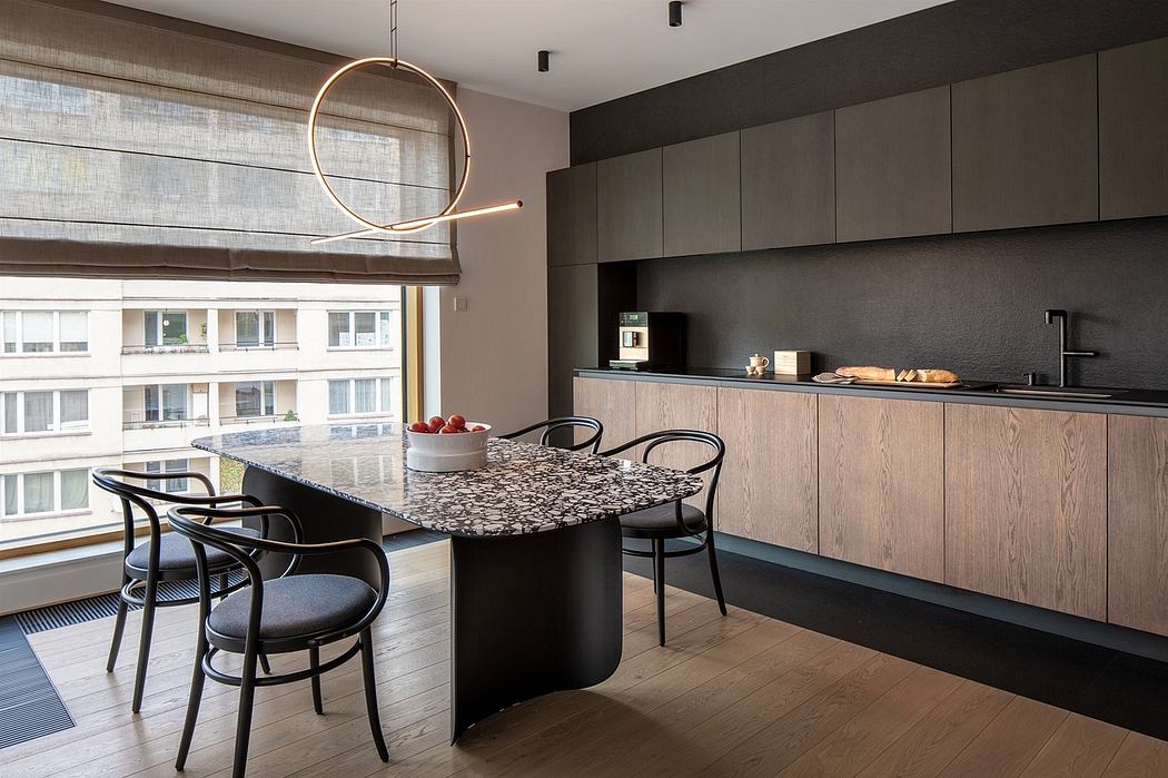 Modern kitchen with a circular light fixture, bar seating, and dark cabinetry.