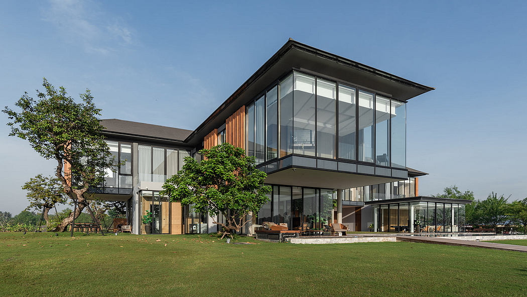 Modern two-story house with large glass windows and wooden panels.