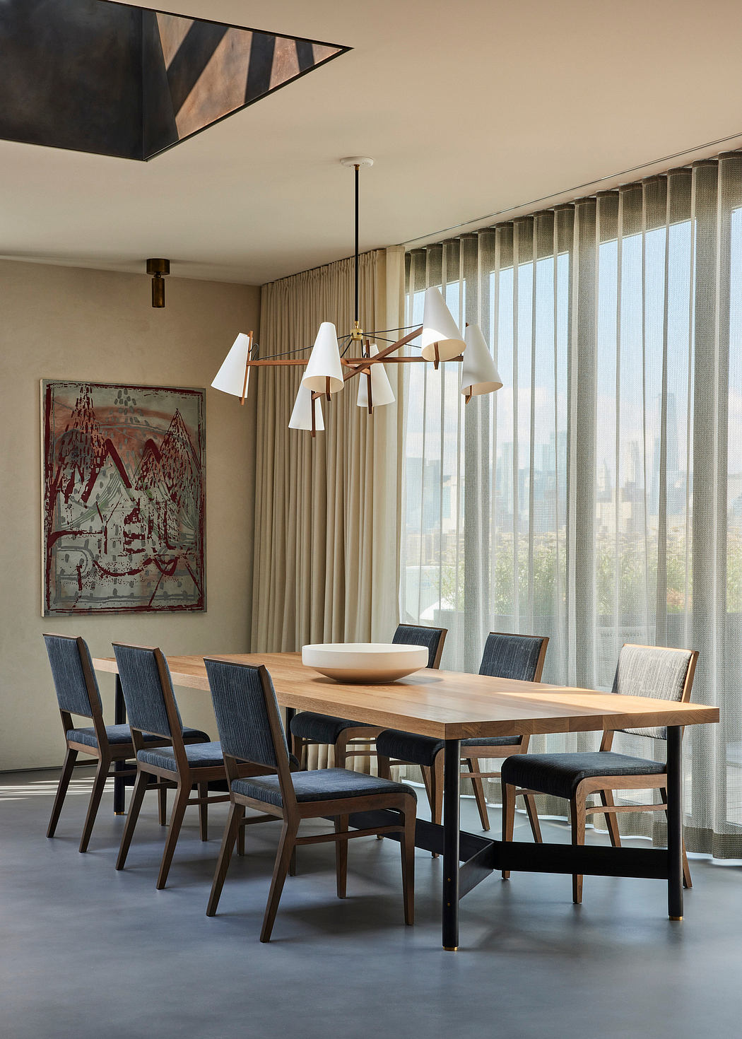 Modern dining room with wooden table, chairs, and artistic hanging light fixture.