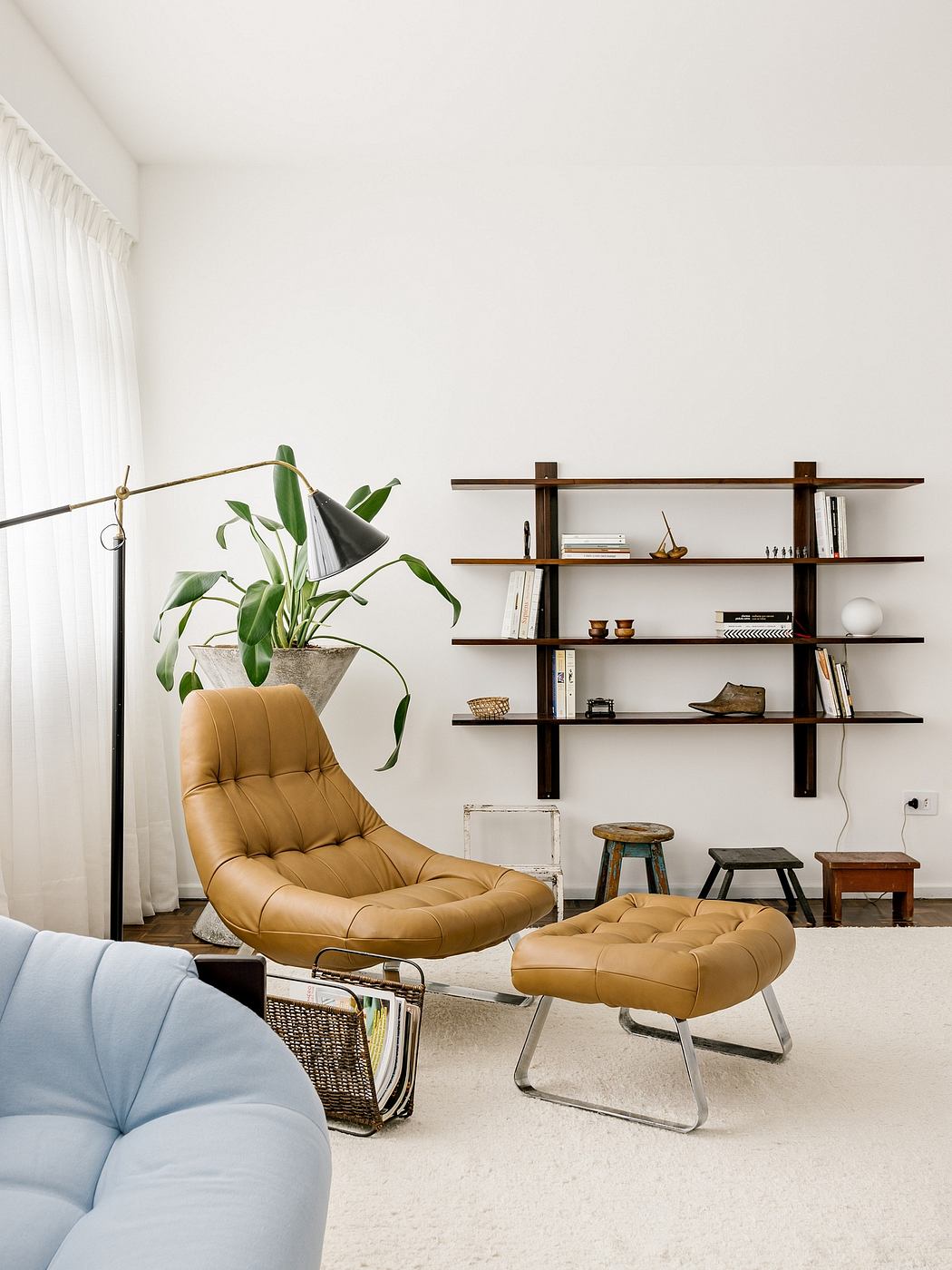 Minimalist living space with tan leather chair and shelving.