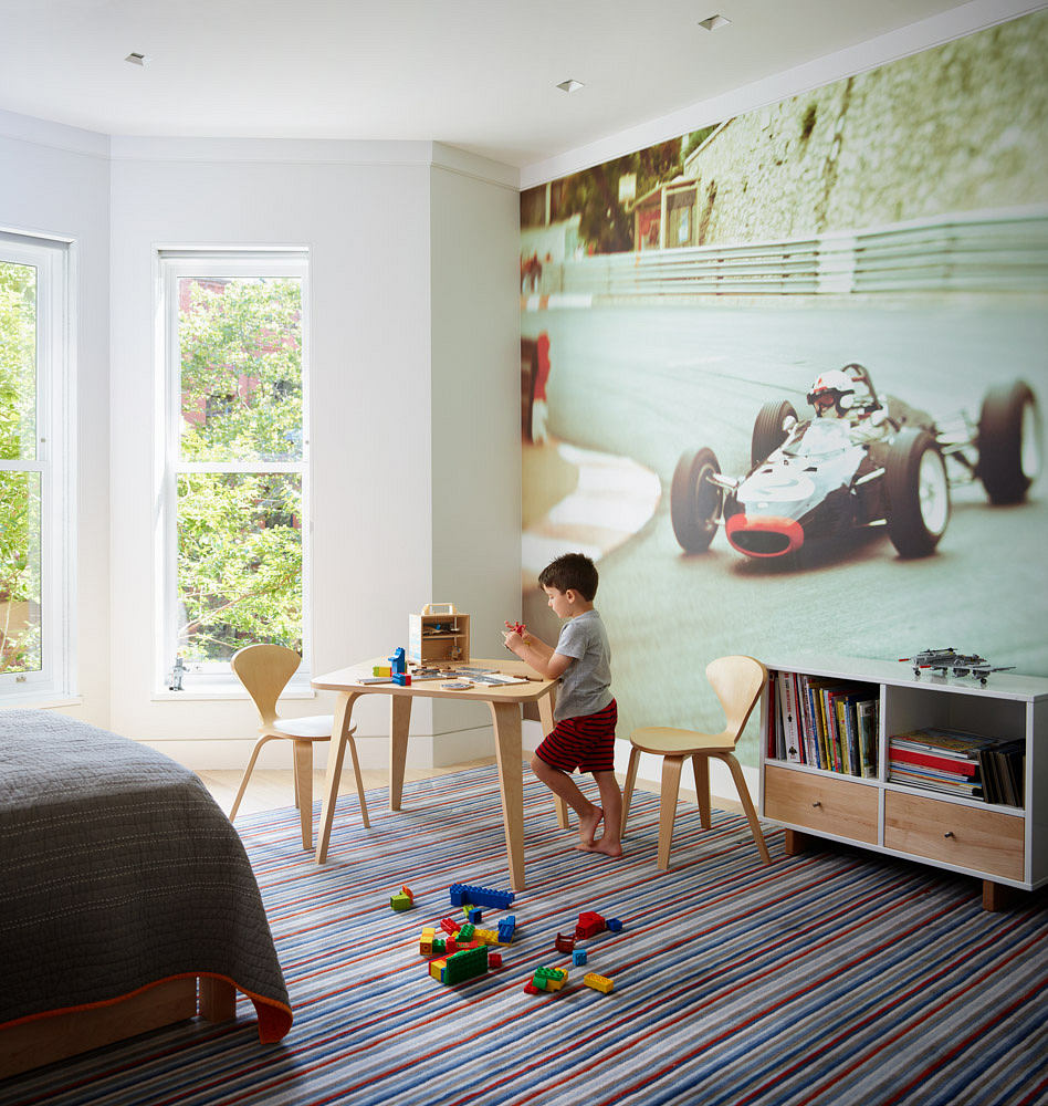 Bright, airy child's room with a large racing car mural and colorful striped rug