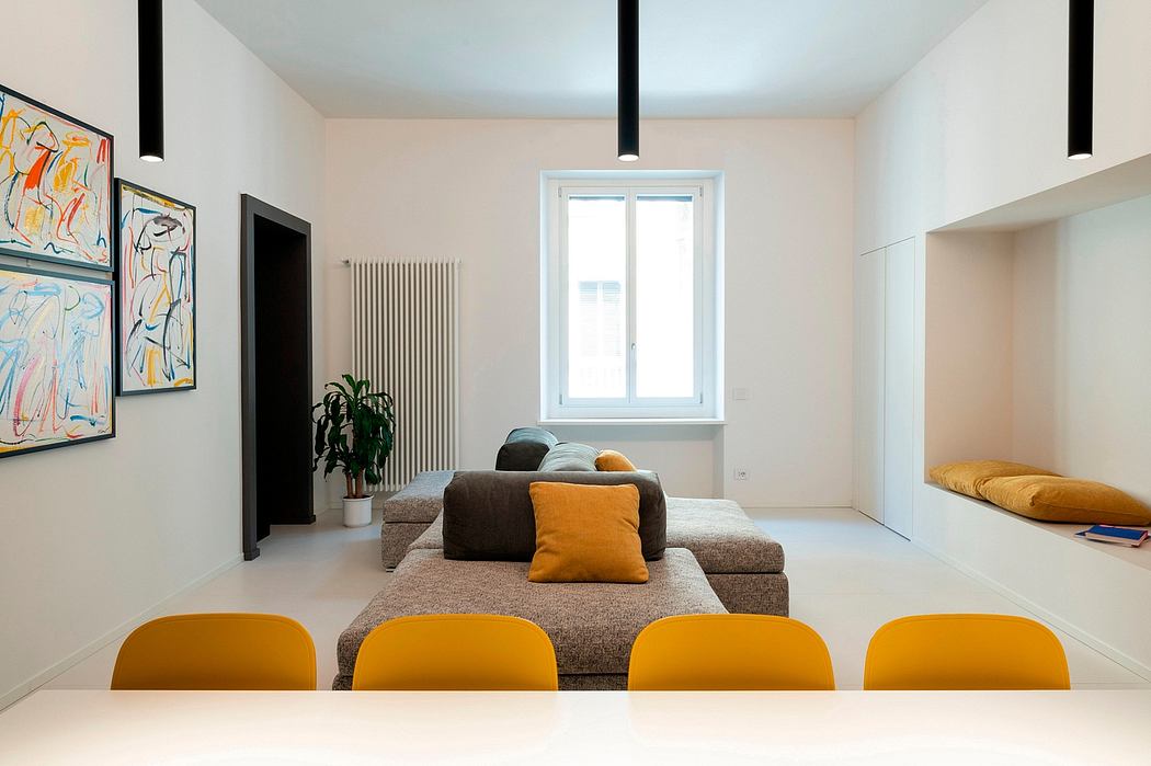 Modern living room with yellow chairs, brown sofa, and colorful art.