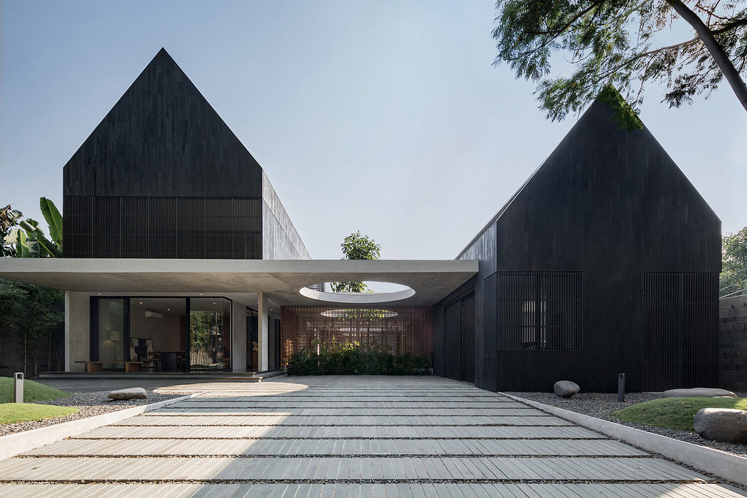 Modern house with geometric black facades and a central courtyard.