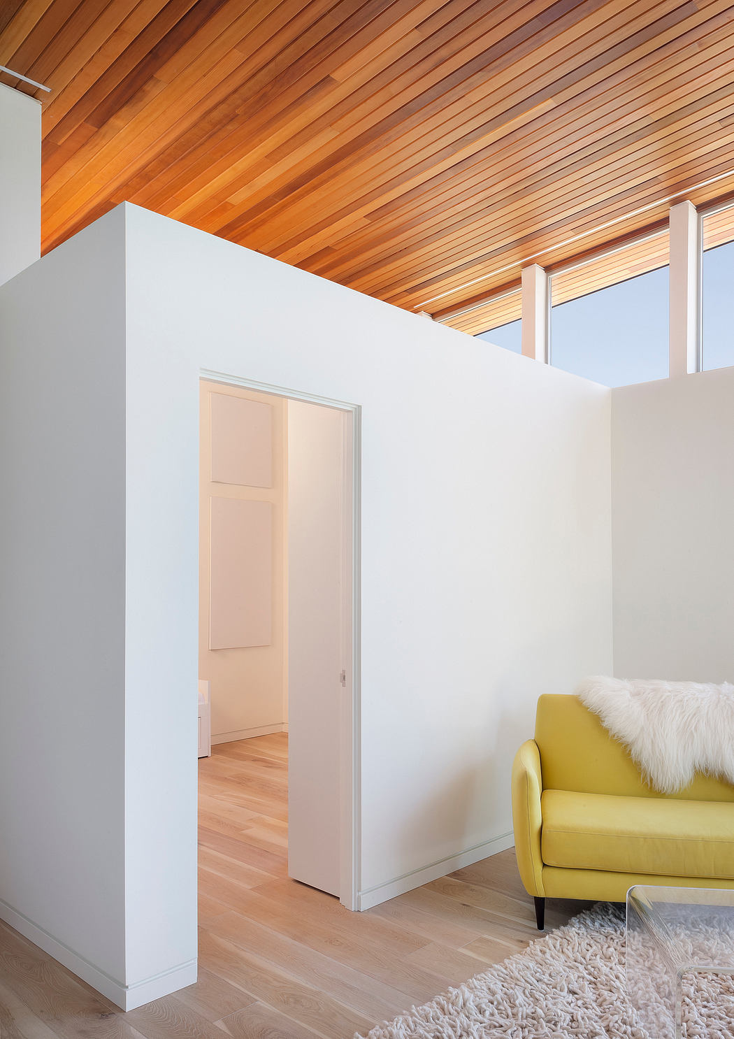 Contemporary room with slatted wooden ceiling and yellow sofa.