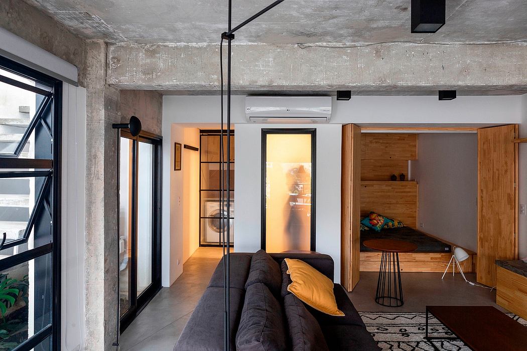 Industrial-style interior with exposed beams, minimalist furniture, and warm lighting.