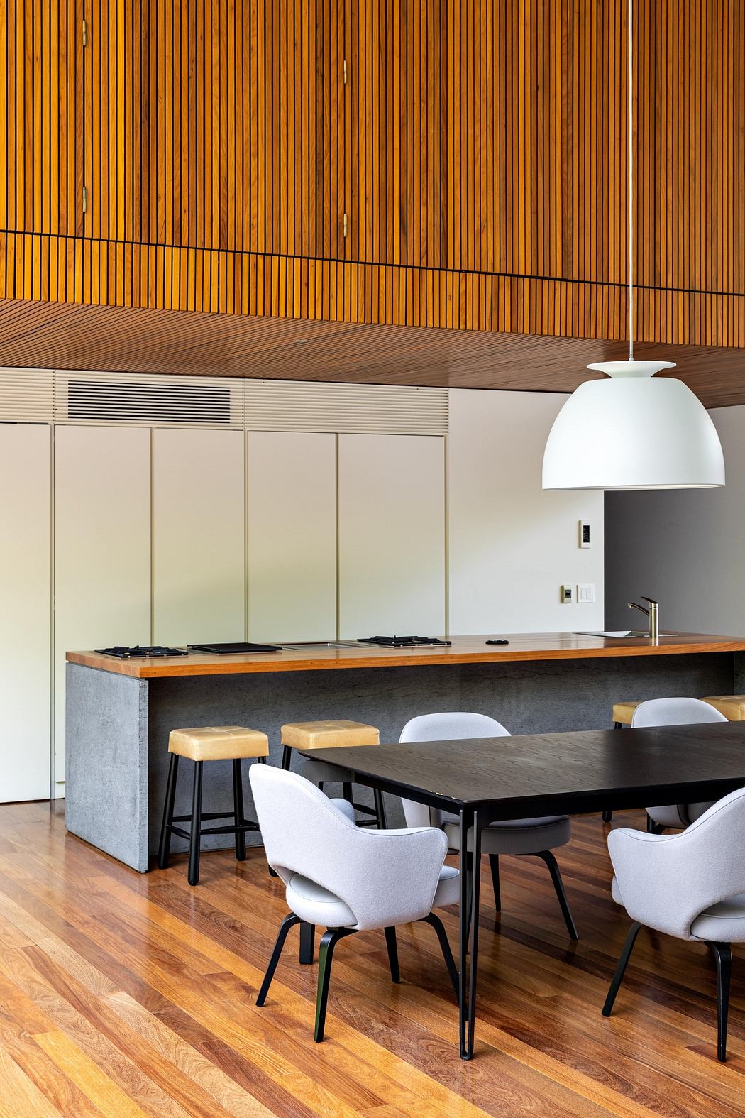 Contemporary kitchen with wooden slatted ceiling and minimalist furniture.