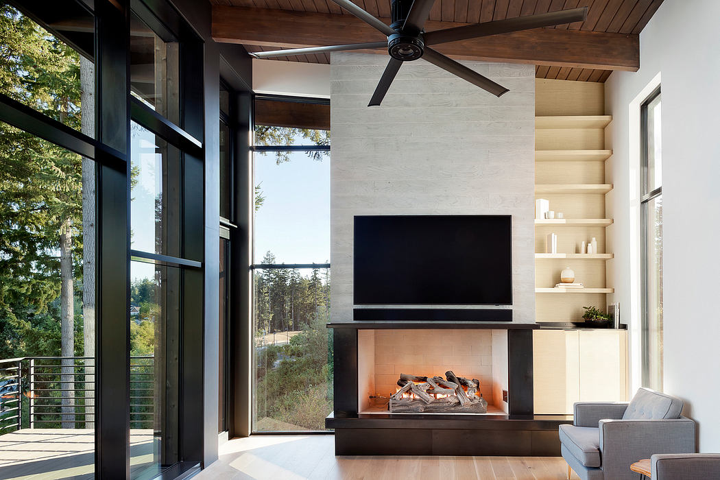 Contemporary room with fireplace, large windows, and nature view.