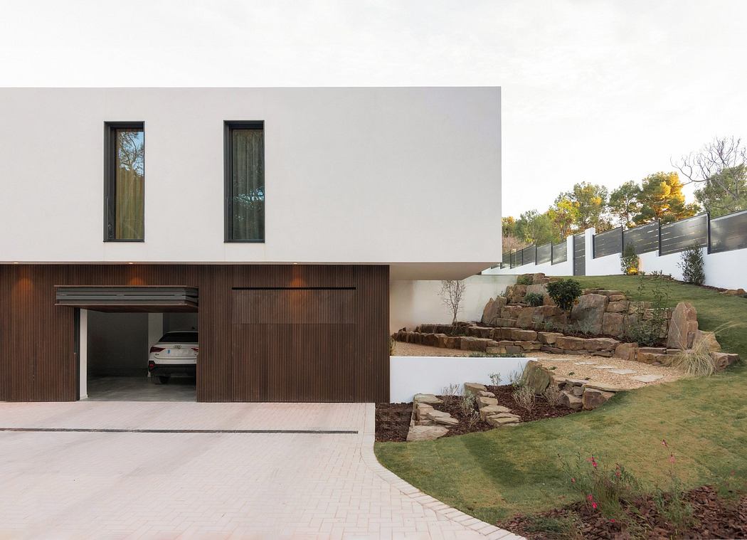 Modern house with white facade, wooden garage door, and landscaped garden.