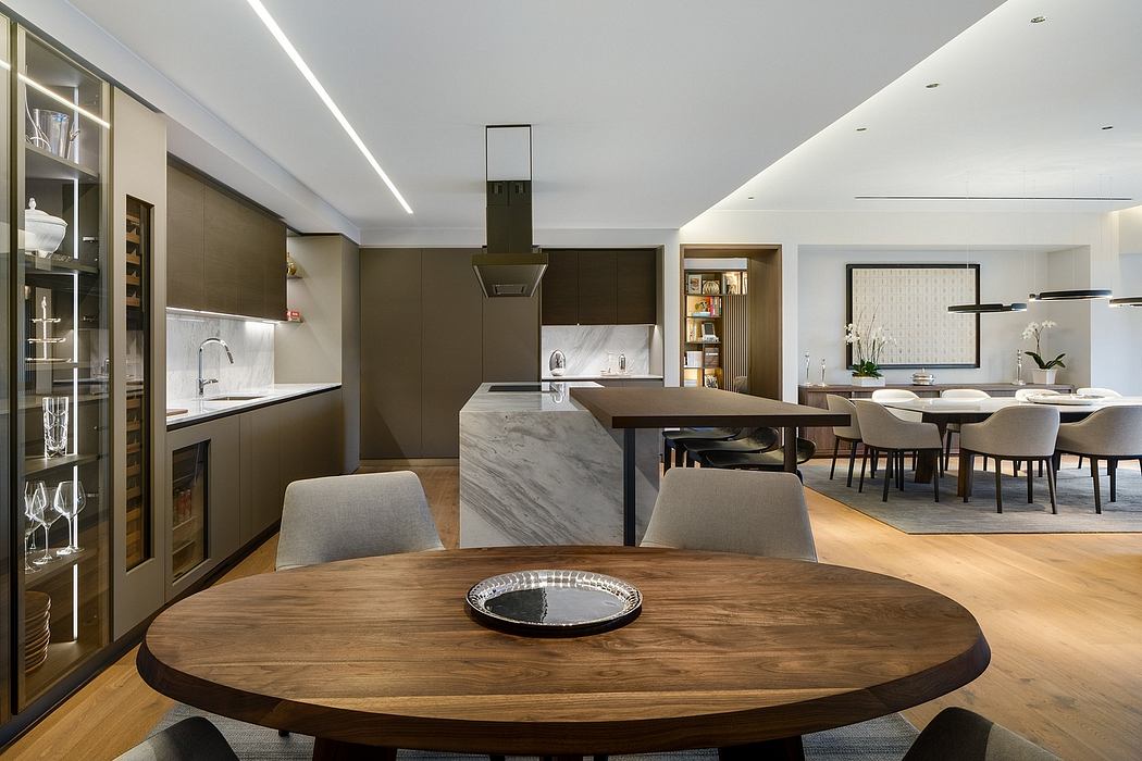 Modern kitchen with island, dining area, and elegant lighting.