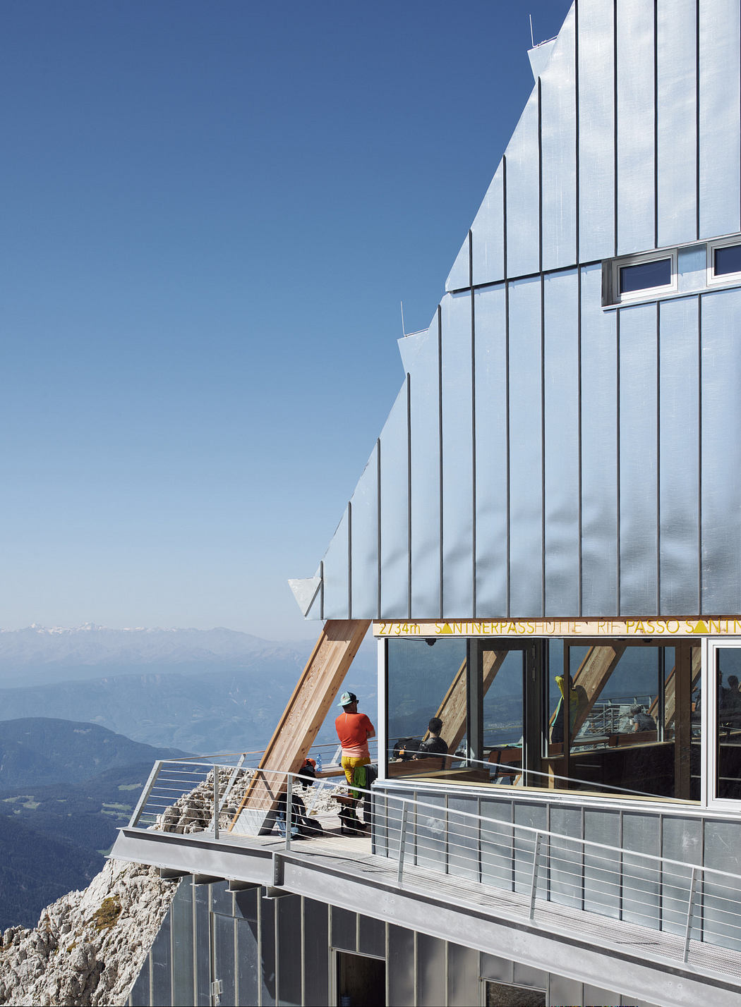 Modern mountain building with worker and panoramic view.