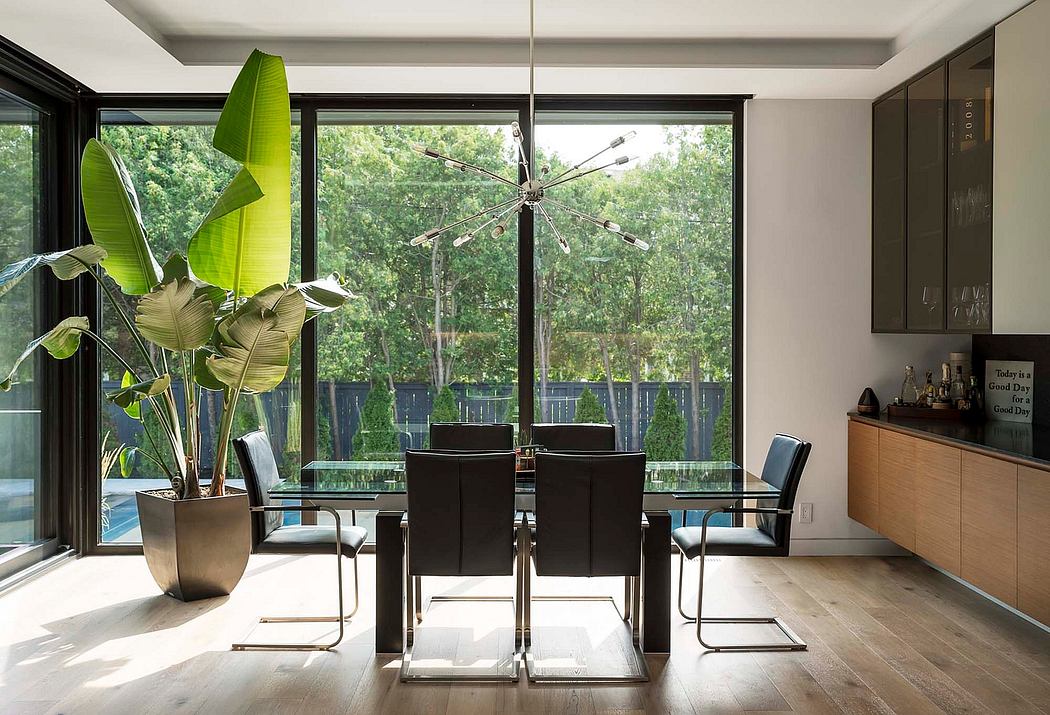 Contemporary dining room with large windows, minimalist decor, and a central hanging light