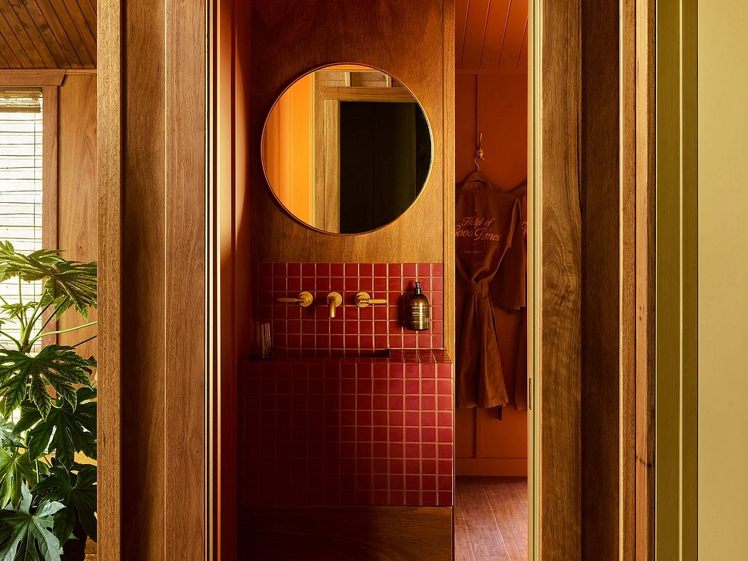 Contemporary bathroom with red tiles, circular mirror, and wooden accents.