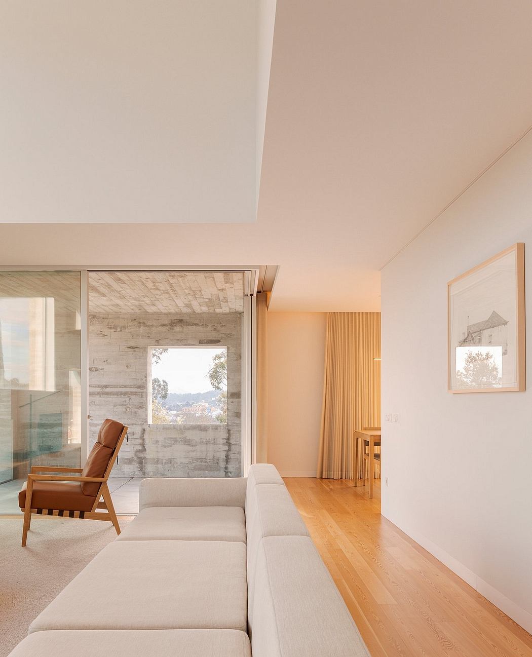 Modern living room with beige sofa, wooden floor, and large window.