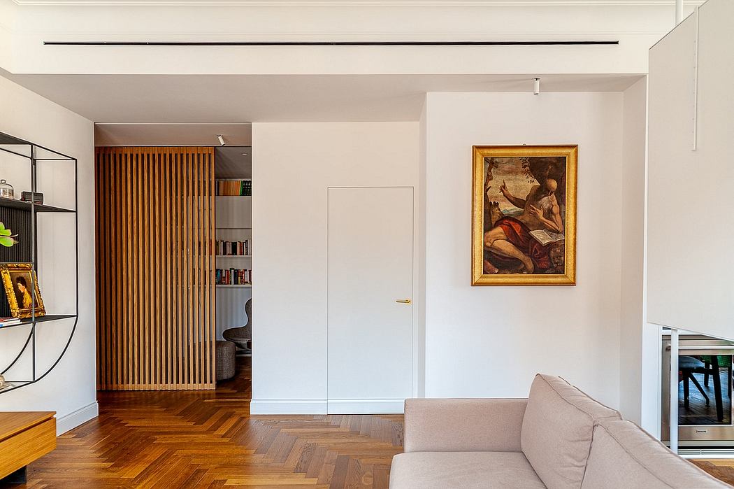 Modern living room with sofa, framed art, and wooden floor.