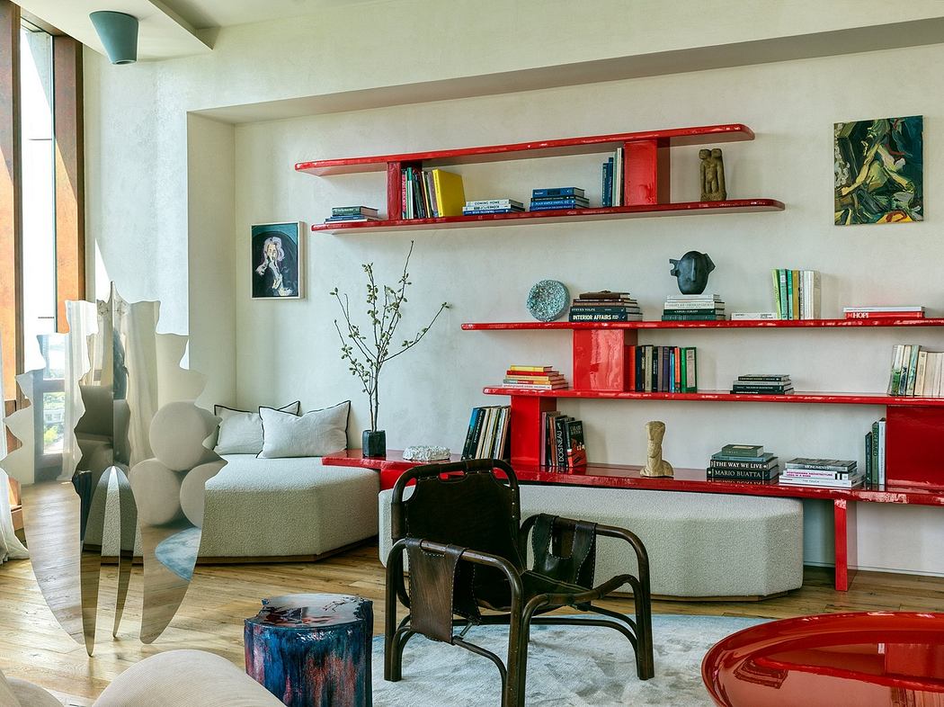 Modern living room with red shelves, books, artworks, and designer furniture.