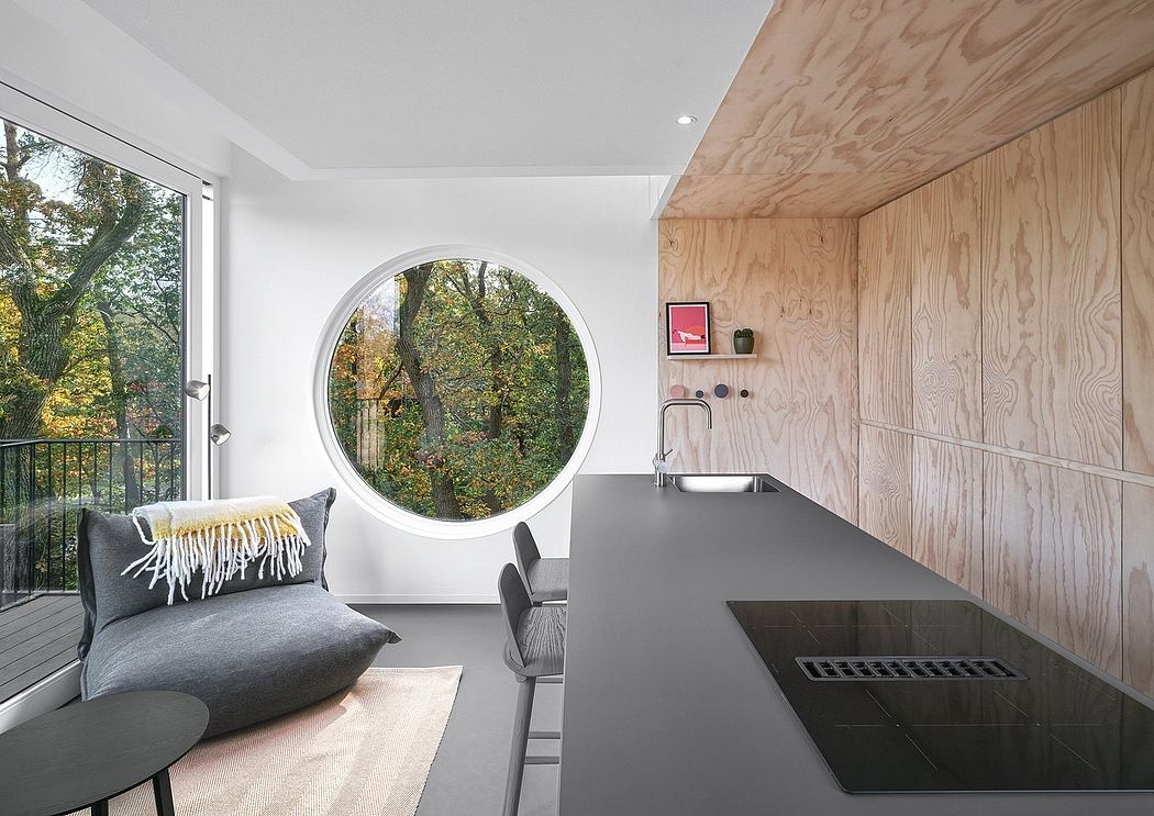 Sleek kitchen with wood accents and circular window.