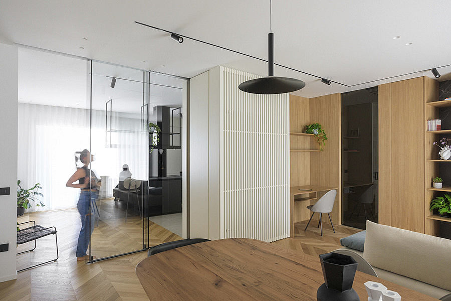 Modern living space with wooden finishes and glass partitions.