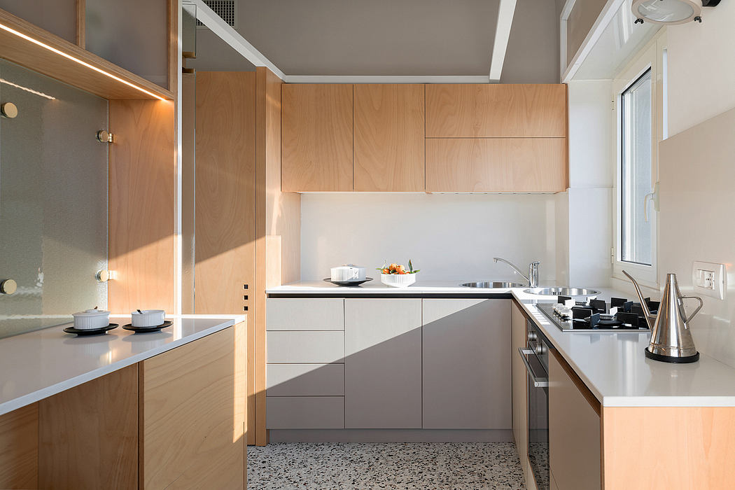 Contemporary kitchen with light wood cabinets and terrazzo flooring.