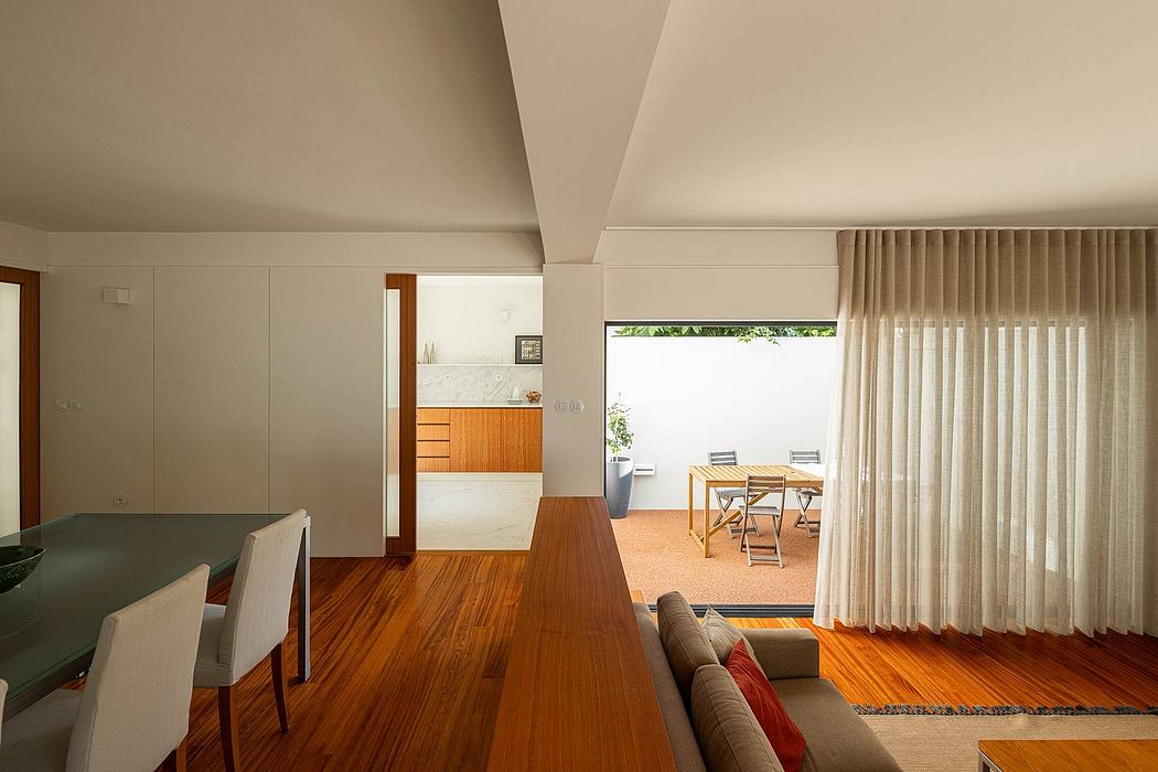Modern living room with wooden floors, white walls, and access to outdoor patio.