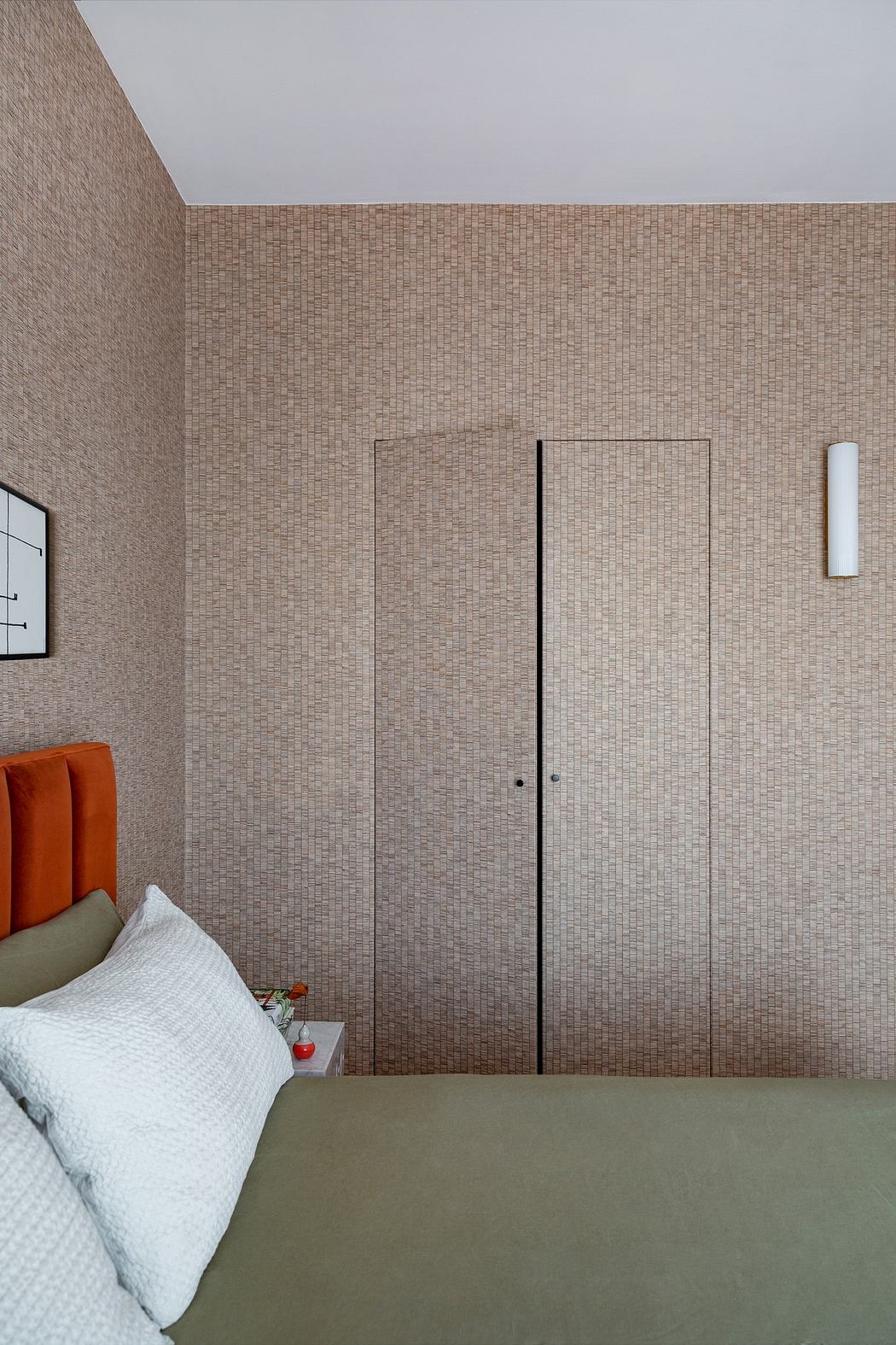 Minimalist bedroom with textured wall and concealed door