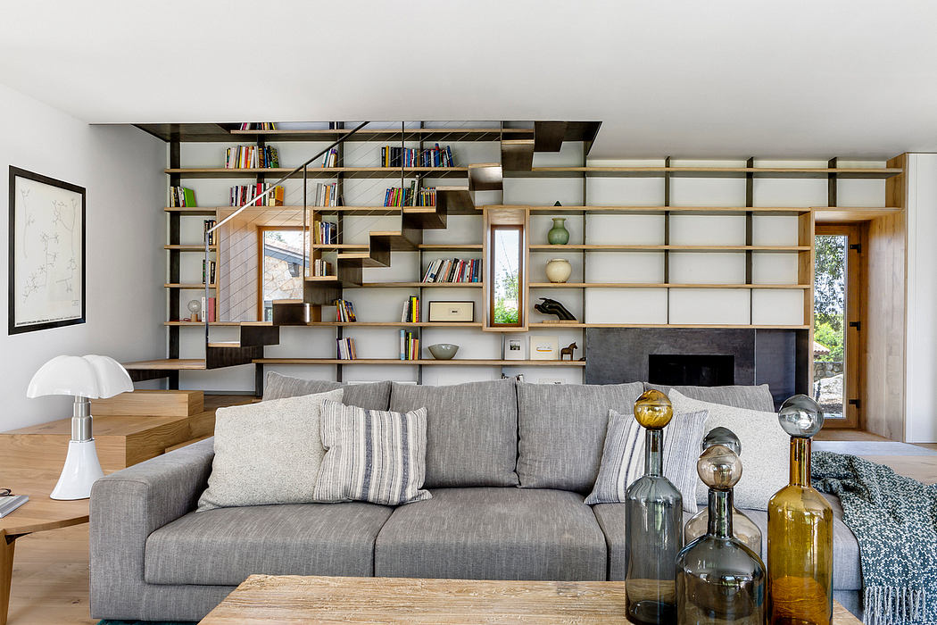 Modern living room with geometric shelving unit and gray sectional sofa.
