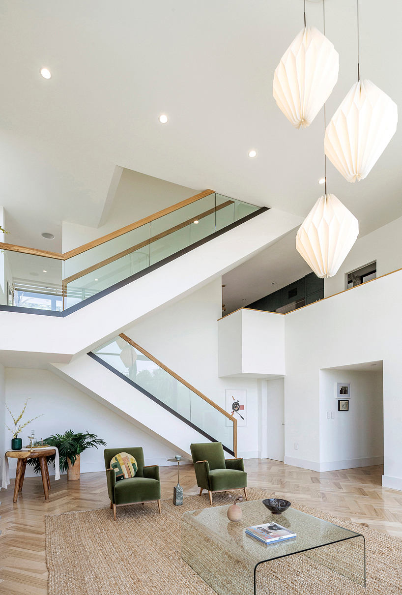 Bright modern living room with staircase and unique pendant lights.