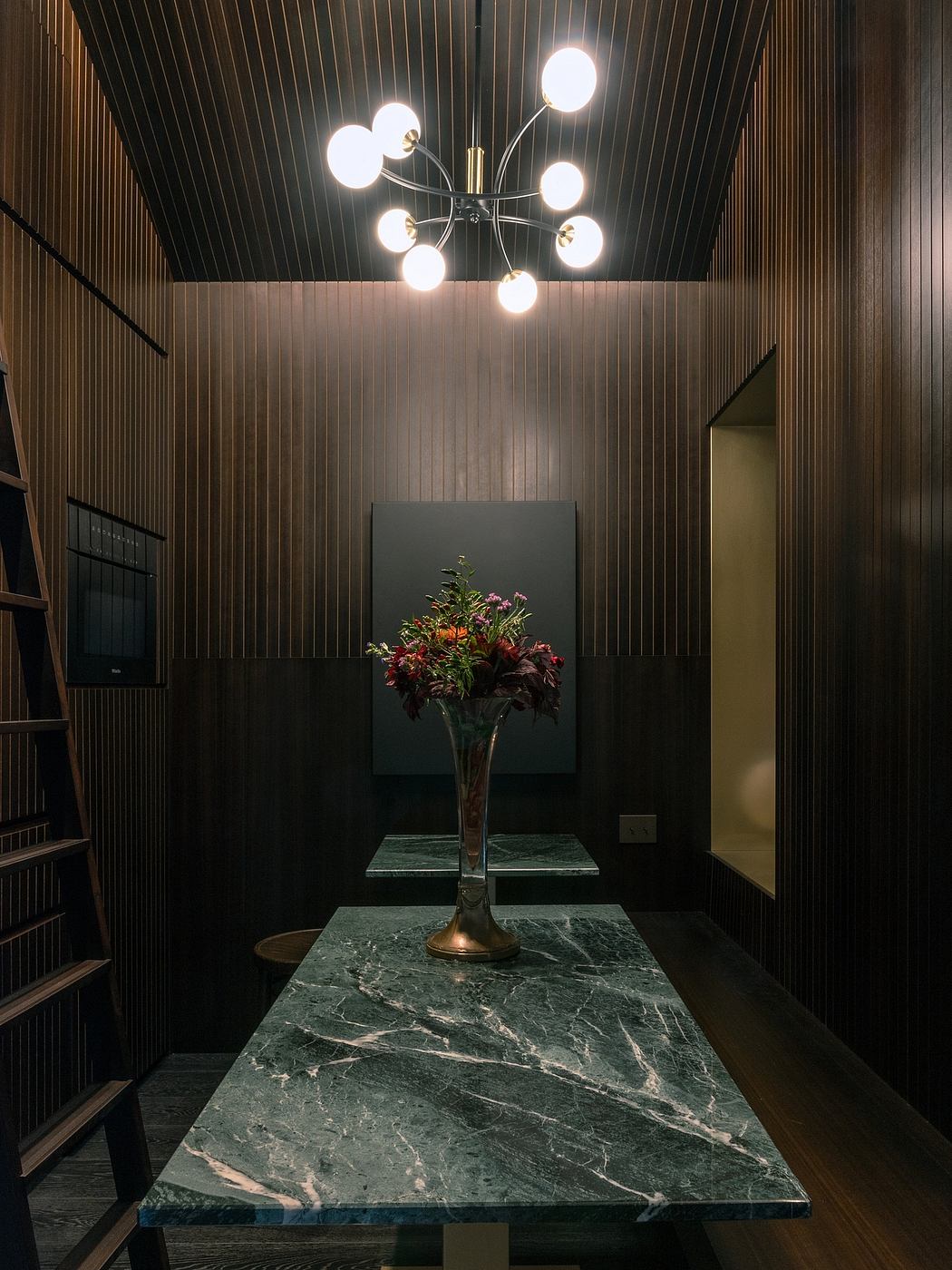 Modern room with wooden walls, a marble table, and a stylish ceiling light fixture