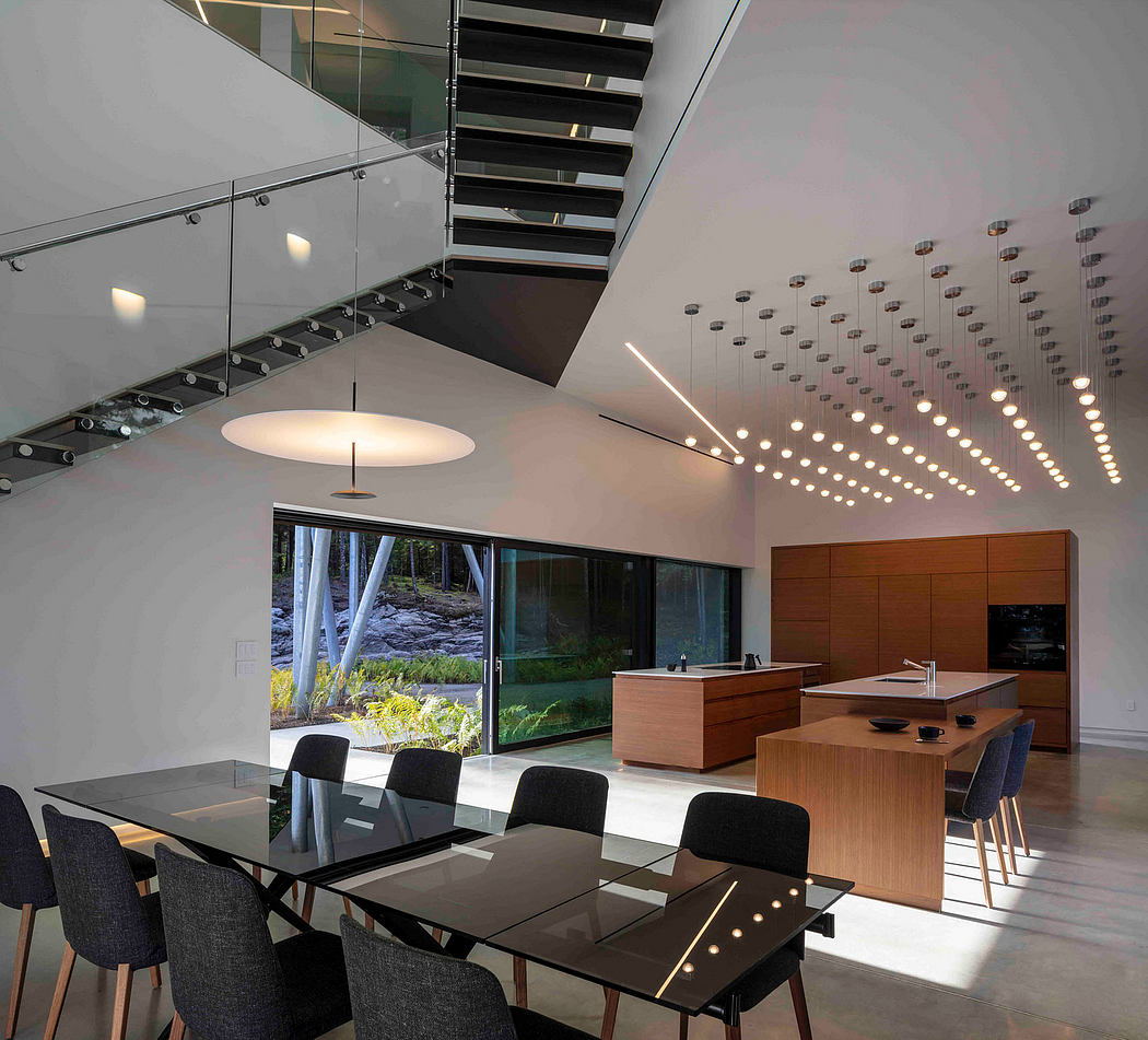 Modern office interior with glass walls, pendant lighting, and a sleek table setup.