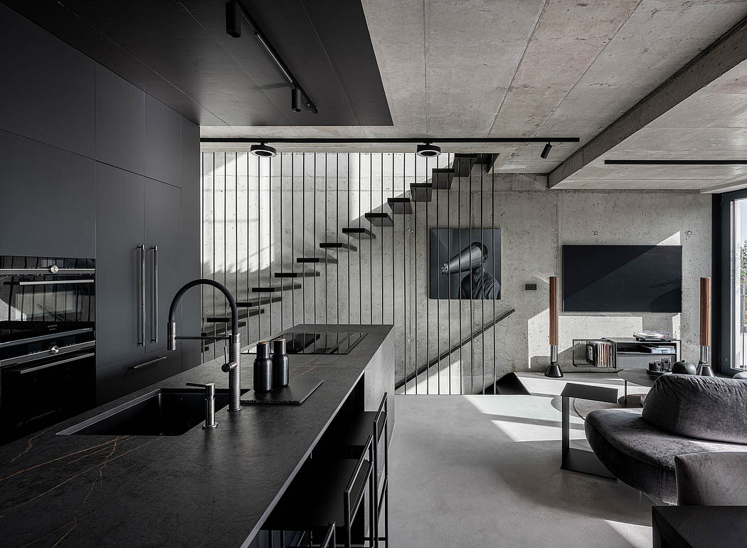 Monochromatic kitchen with floating staircase and concrete accents.