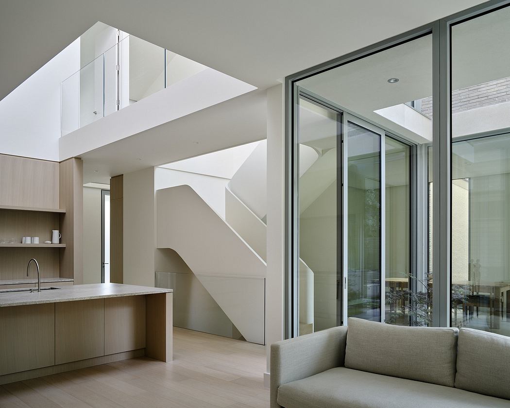 Modern interior with a staircase, glass doors, and minimalistic furniture.