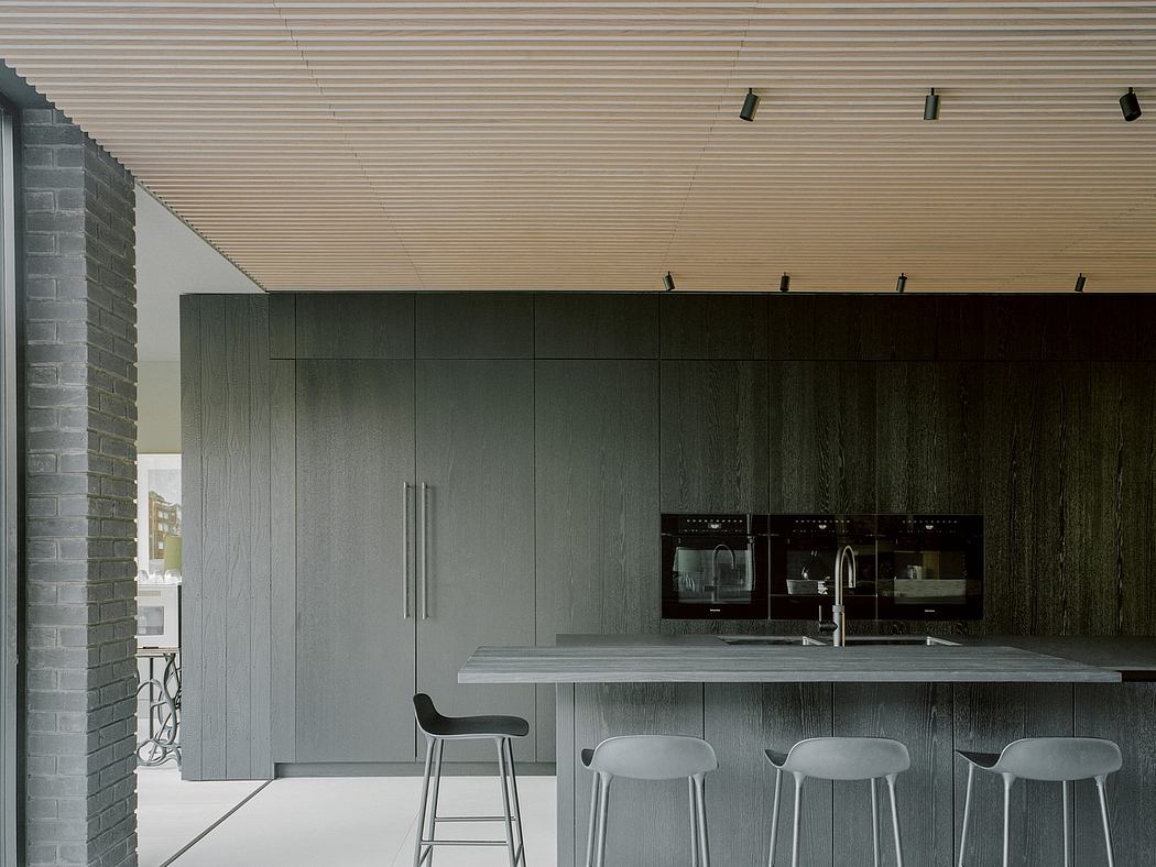 Modern kitchen with dark wood cabinets and bar stools.