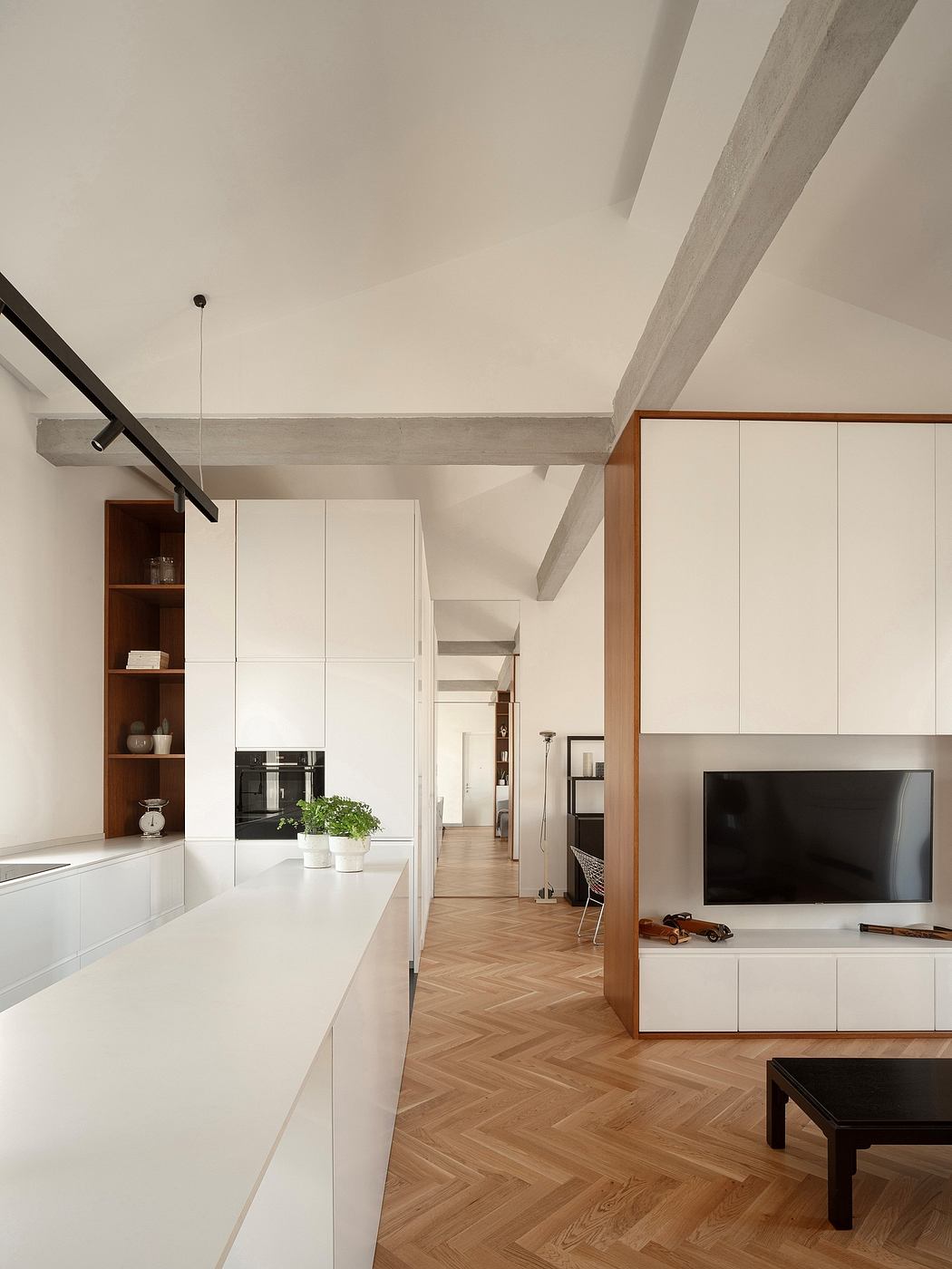 Minimalist interior with white cabinetry, herringbone floor, and exposed beams
