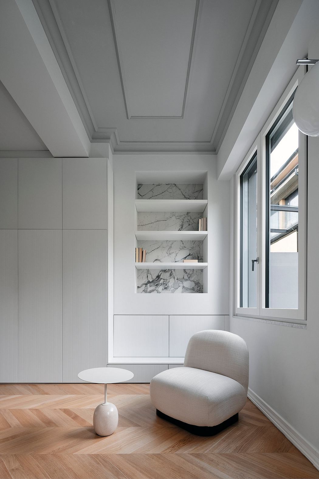 Elegant room with herringbone floor and white marble shelves.