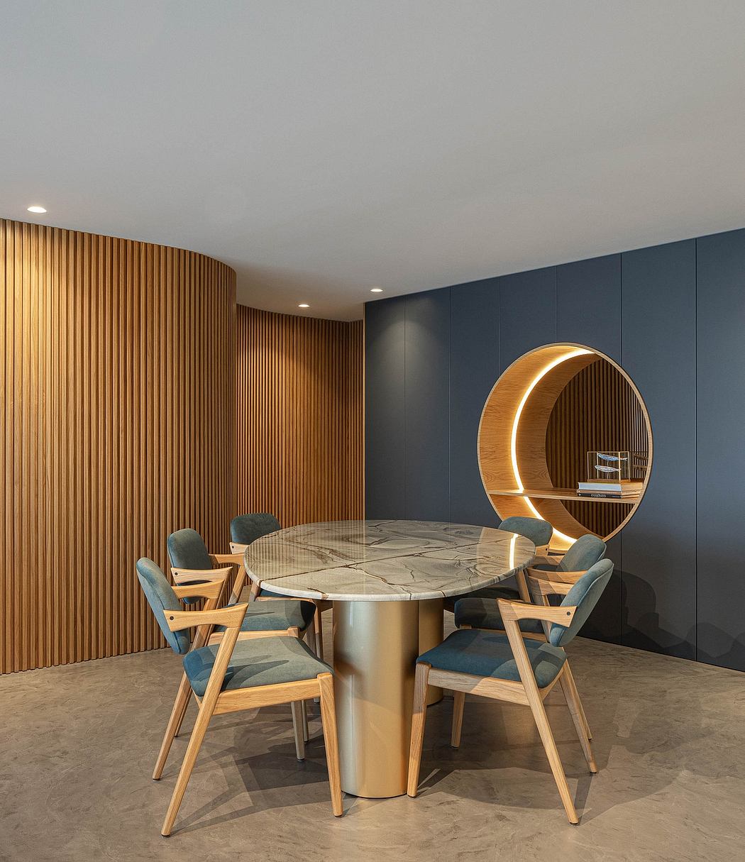 Modern dining room with a round table, blue chairs, and an artistic wooden shel