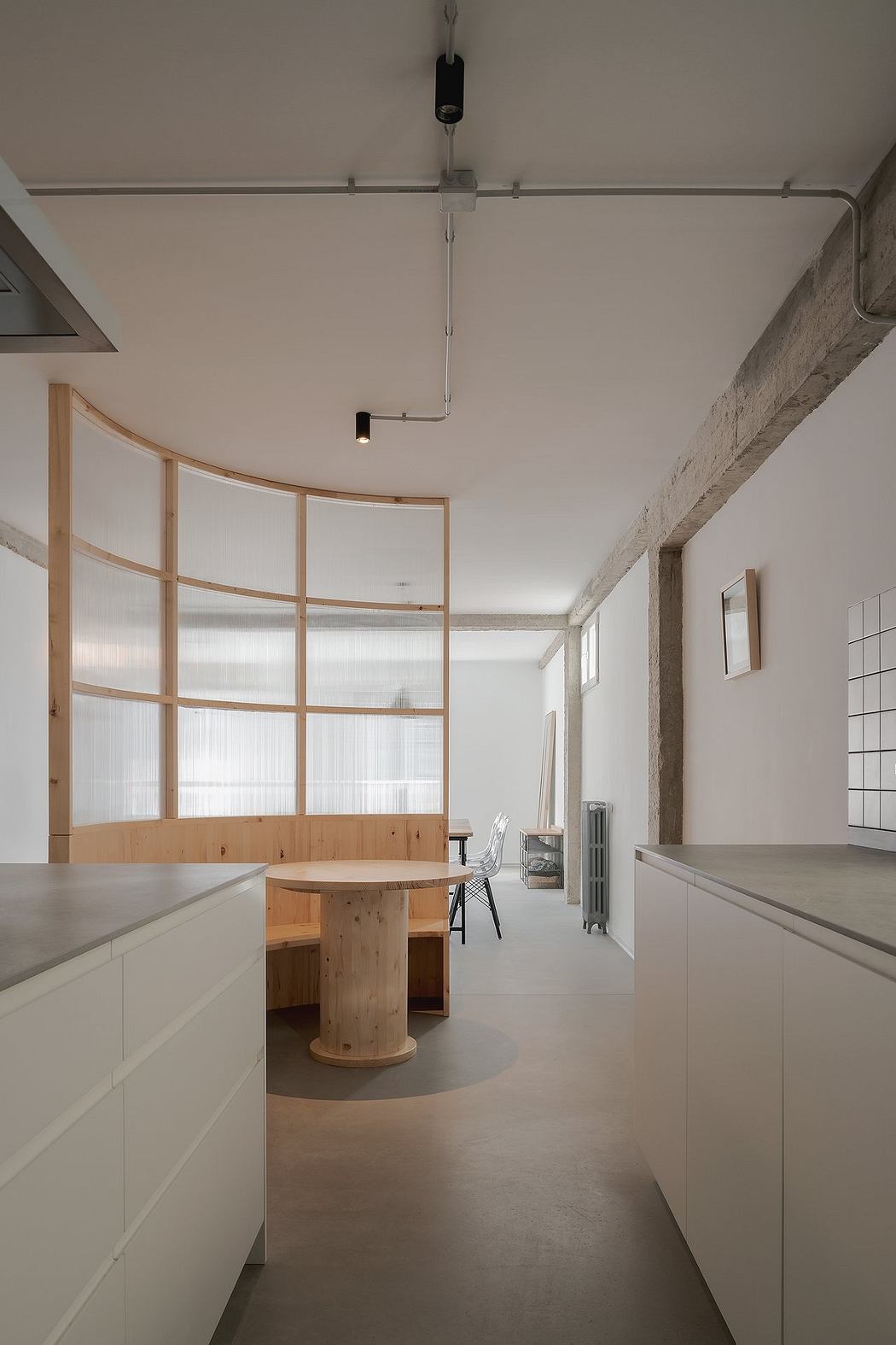 Minimalist interior with white cabinets, wooden table, and translucent room dividers.