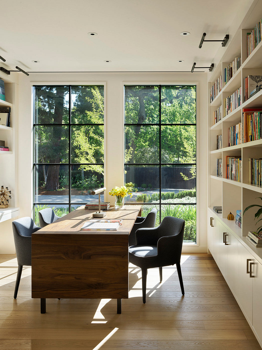 Bright home office with large window, bookshelves, and a wooden desk.