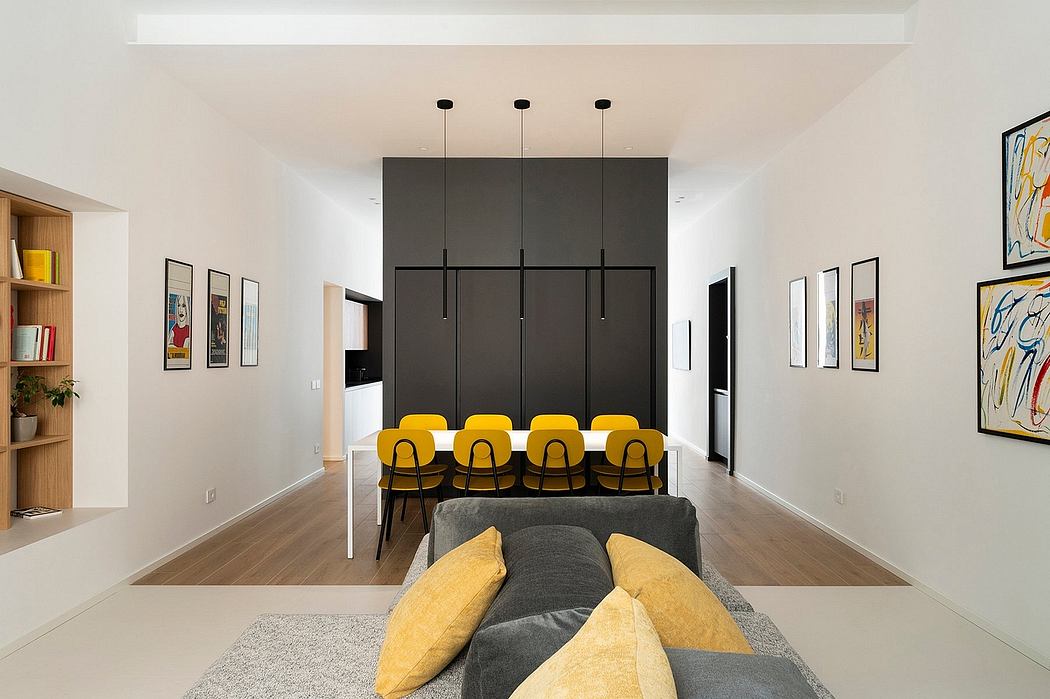 Modern dining room with yellow chairs, art on walls, and black cupboard.