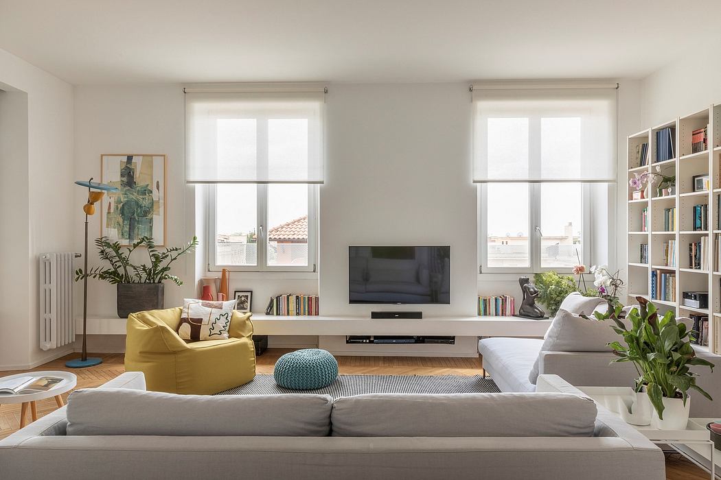Bright living room with white walls, modern furniture, and large windows.