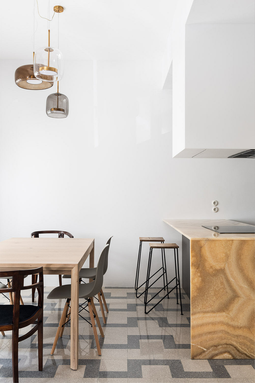 Contemporary dining space with chic pendant lights and patterned floor.