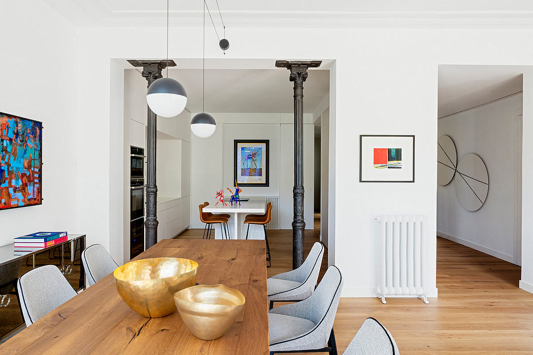 Modern dining room with a wooden table, pendant lights, and artwork on walls.