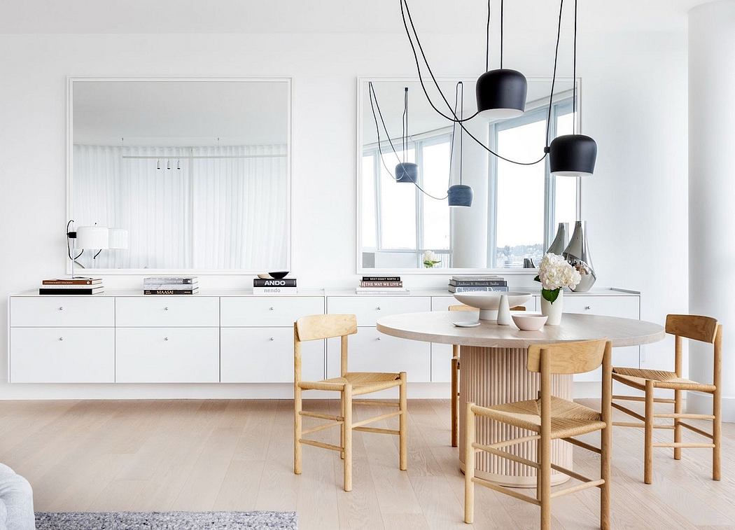Minimalist dining room with sleek white cabinetry and stylish pendant lights.