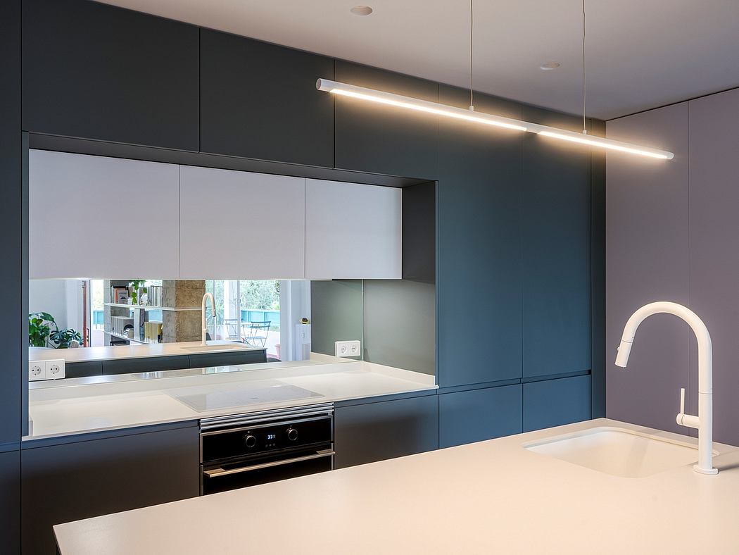 Contemporary kitchen with sleek gray cabinetry and linear lighting.