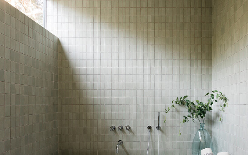 Minimalist tiled bathroom with natural light and plant decor