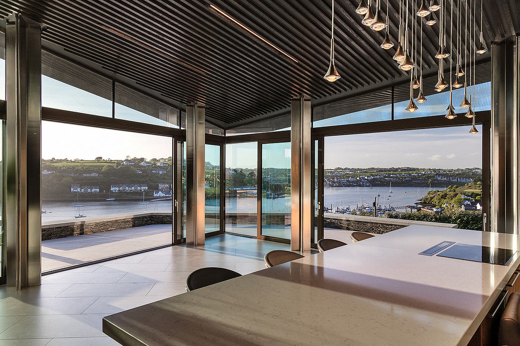Streamlined kitchen with large windows overlooking a water view.