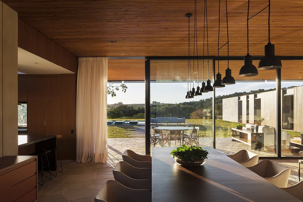Modern dining area with a view of the countryside through large windows.