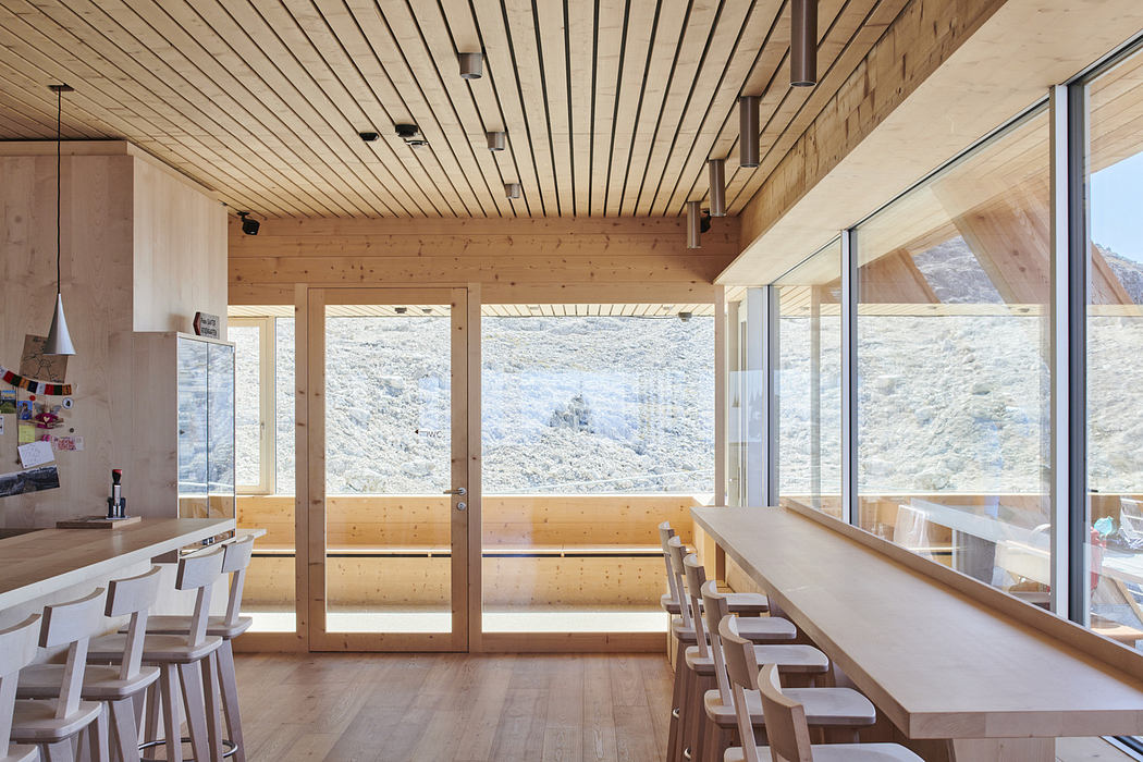 Bright, wooden interior with large windows overlooking mountains.