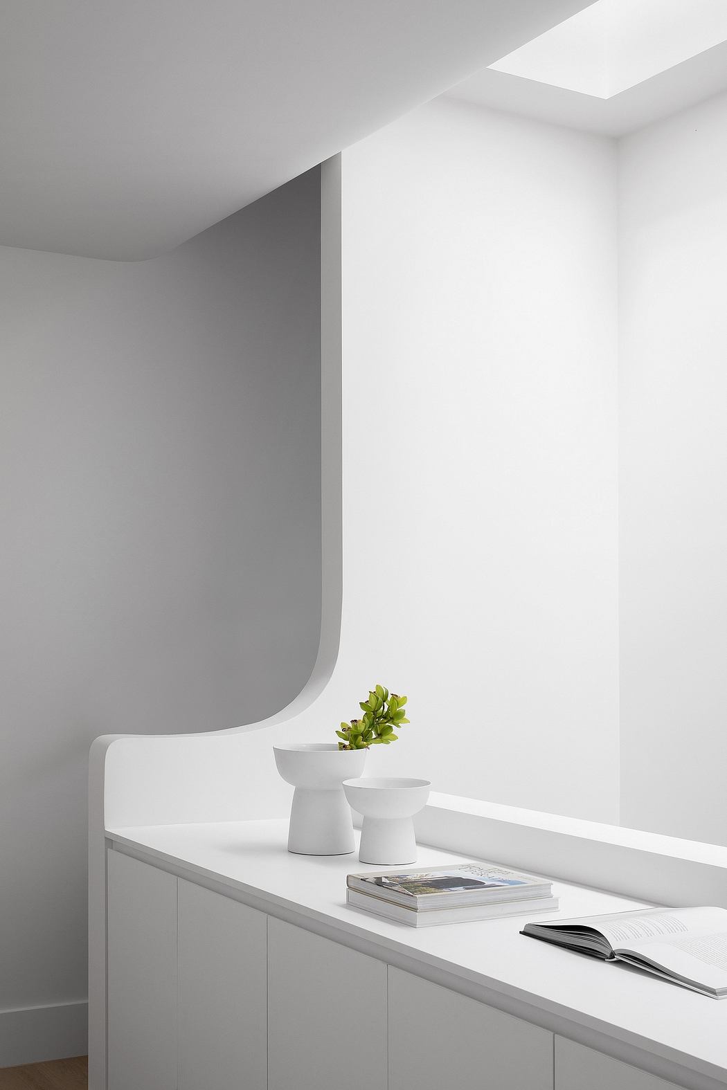 Minimalist white interior with curved features and simple decor.